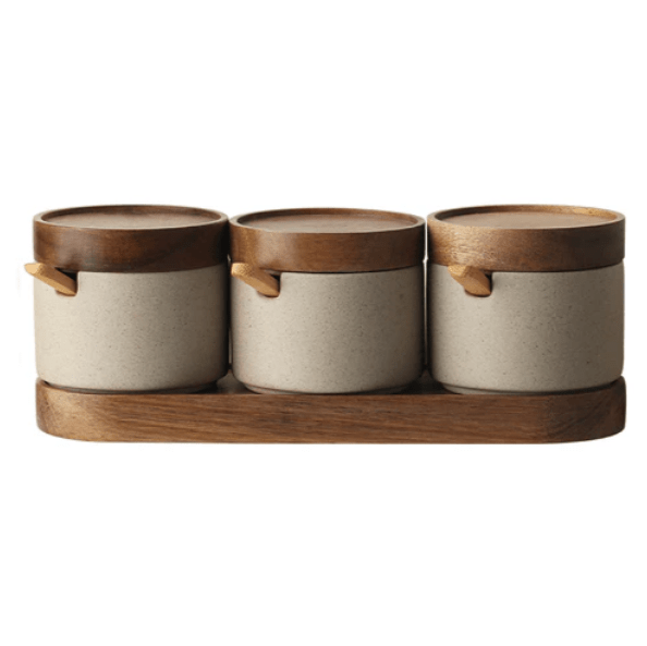 Three sets of ceramic seasoning jars with wooden lids, neatly arranged