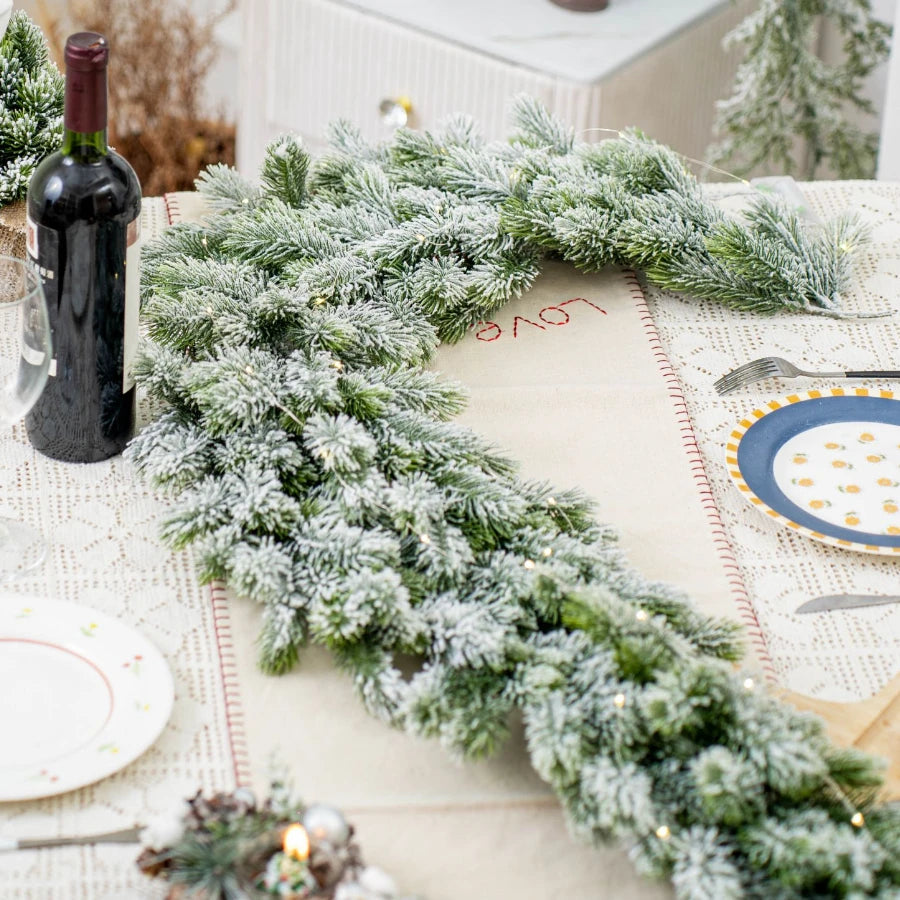 Artificial Christmas tree branch in green and white, ideal for festive table or fireplace decor.