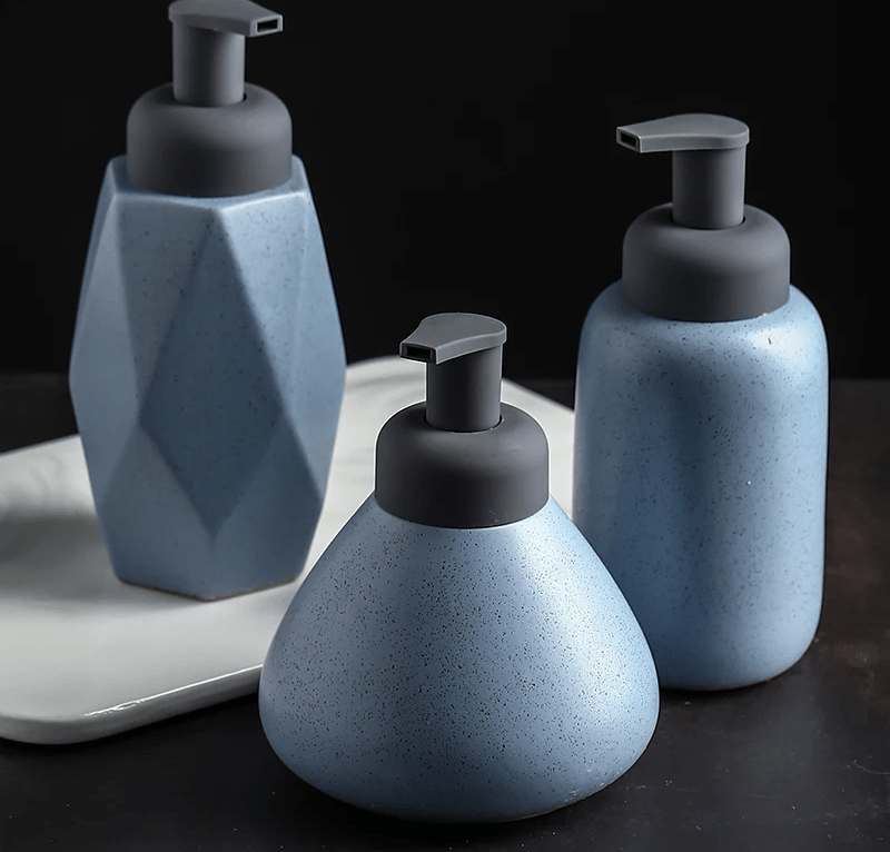 A blue ceramic soap dispenser with a sleek design, ideal for modern bathroom decor.