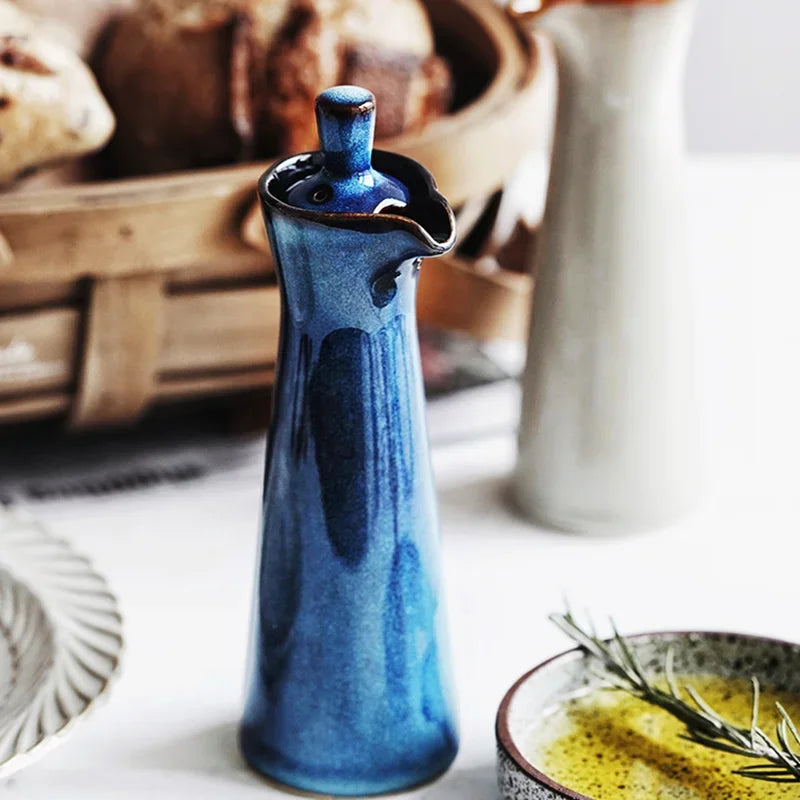 A blue vintage ceramic oil and vinegar dispenser with a classic design and decorative details