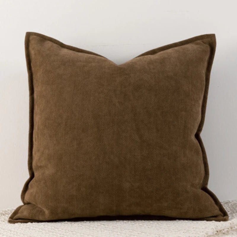 A brown Nordic cushion cover placed over a couch, showcasing its delicate and cozy texture.