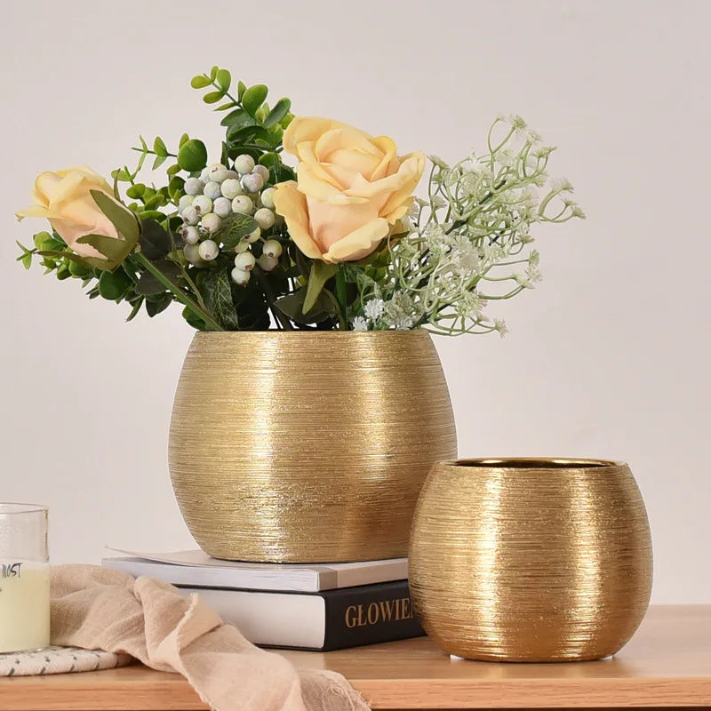 A brushed golden ceramic round vase with smooth curves, perfect for adding a touch of luxury to any home décor.