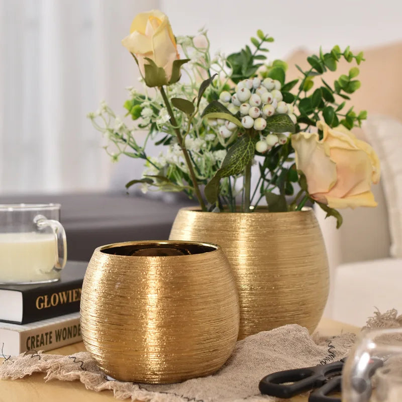 A brushed golden ceramic round vase with smooth curves, perfect for adding a touch of luxury to any home décor.