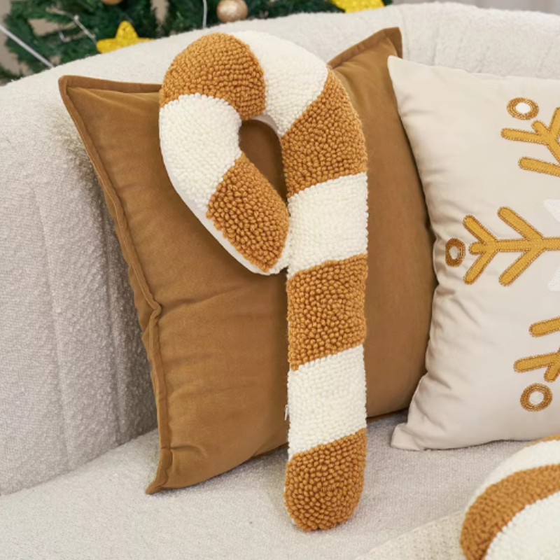 soft candy cane-shaped pillows with gold and white stripes.