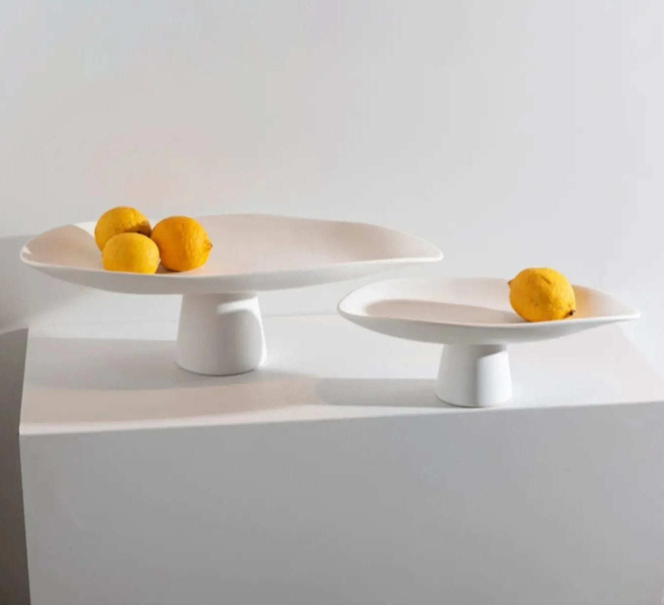 Modern ceramic high centerpiece tray in black or white with curvy, irregular lines, perfect as decor or fruit holder.