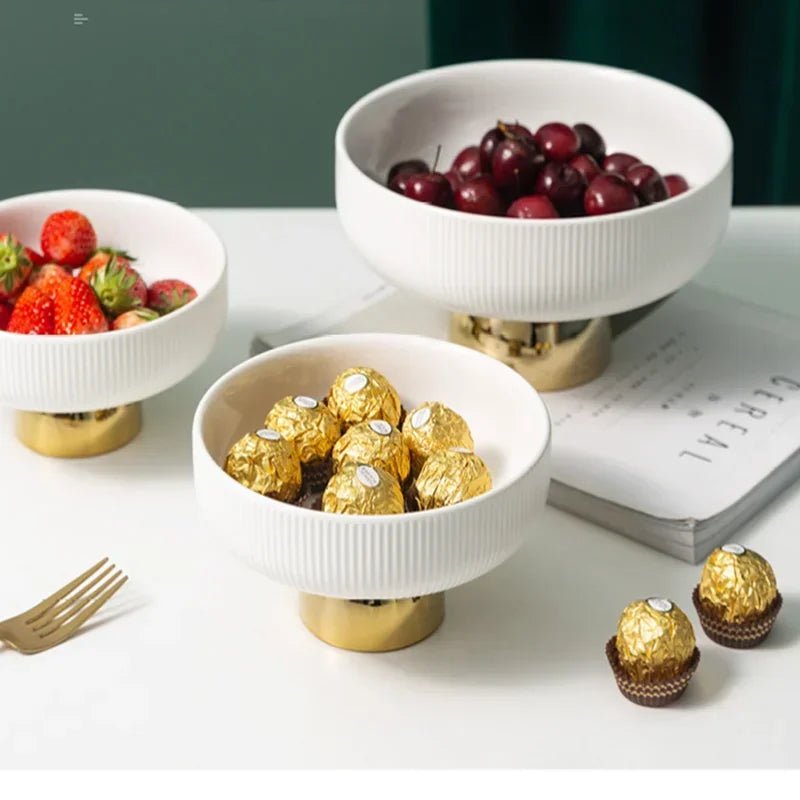 Three ceramic fruit bowls filled with strawberries and candies.