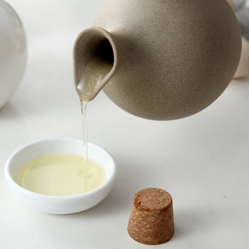 Image of a ceramic oil bottle pouring oil