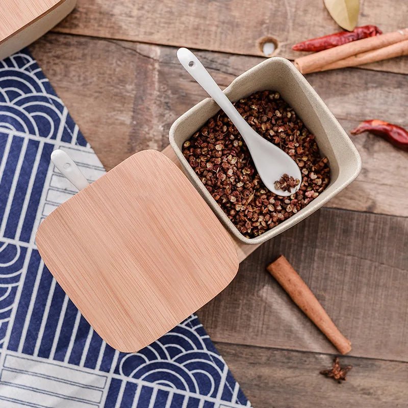 Ceramic seasoning jar set with wooden lids containing various seasonings.