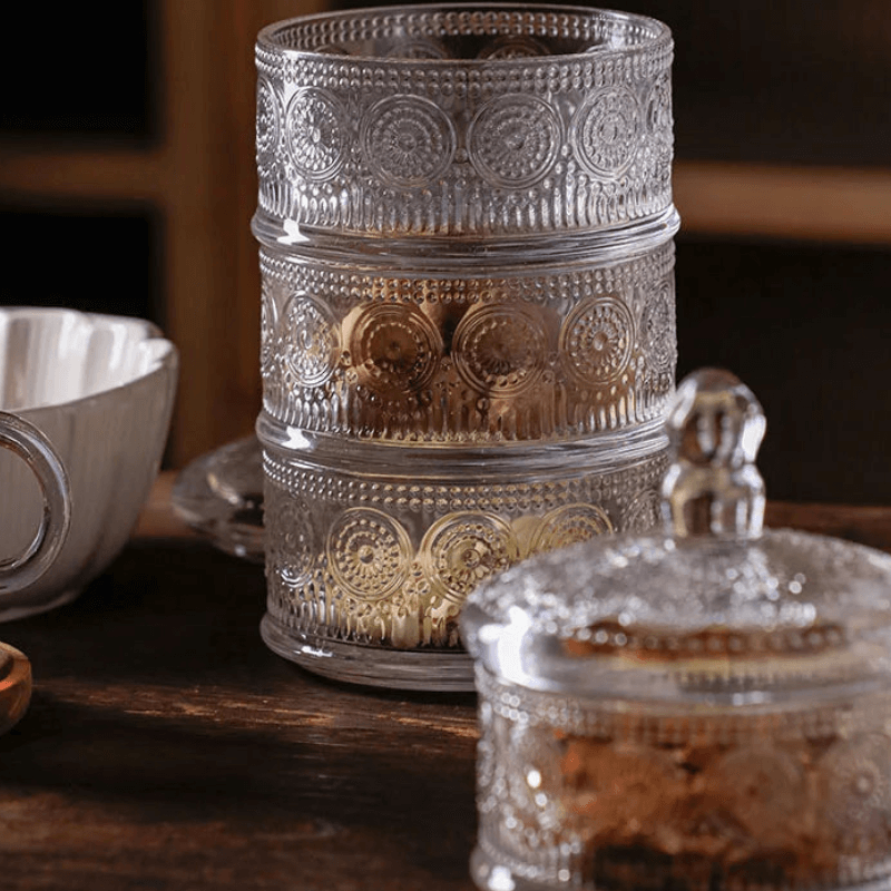 Classic engraved triple-tier glass jar with elegant design, perfect for storage and display in kitchen or home decor.