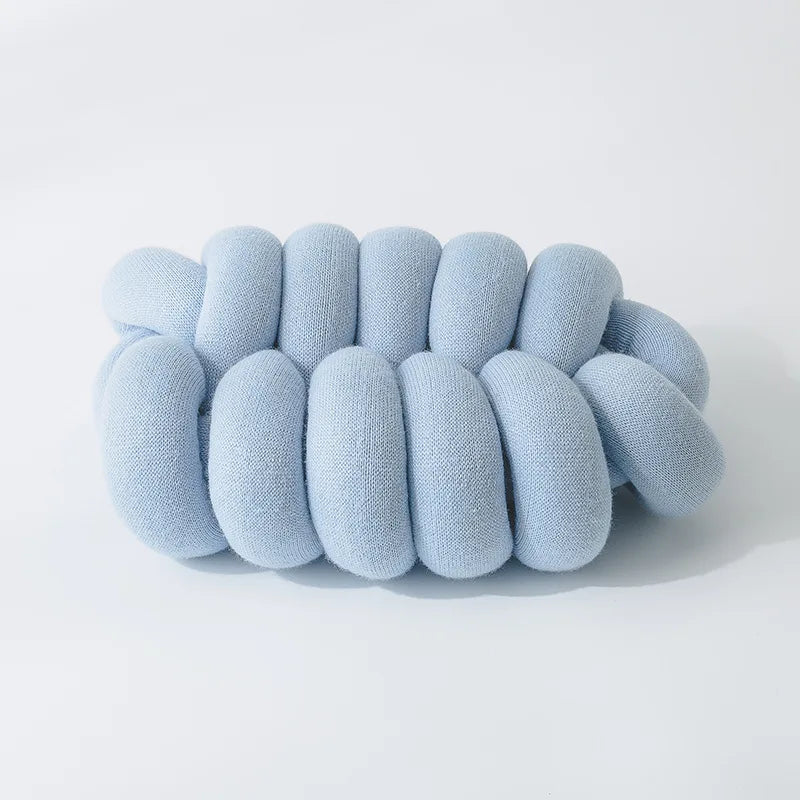 A comfy handmade knot pillow in a modern design, perfect for adding a decorative touch to any living space