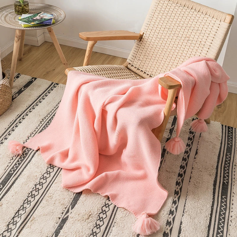 A cozy knitted blanket in a luxurious design draped over a chair.