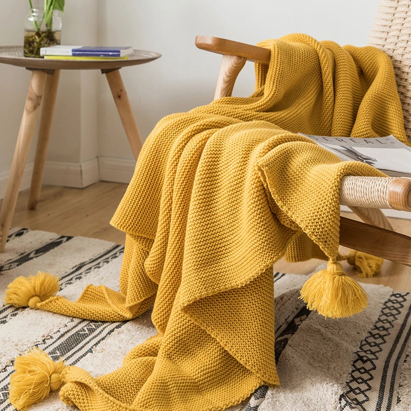 A cozy knitted blanket in a luxurious design draped over a chair.