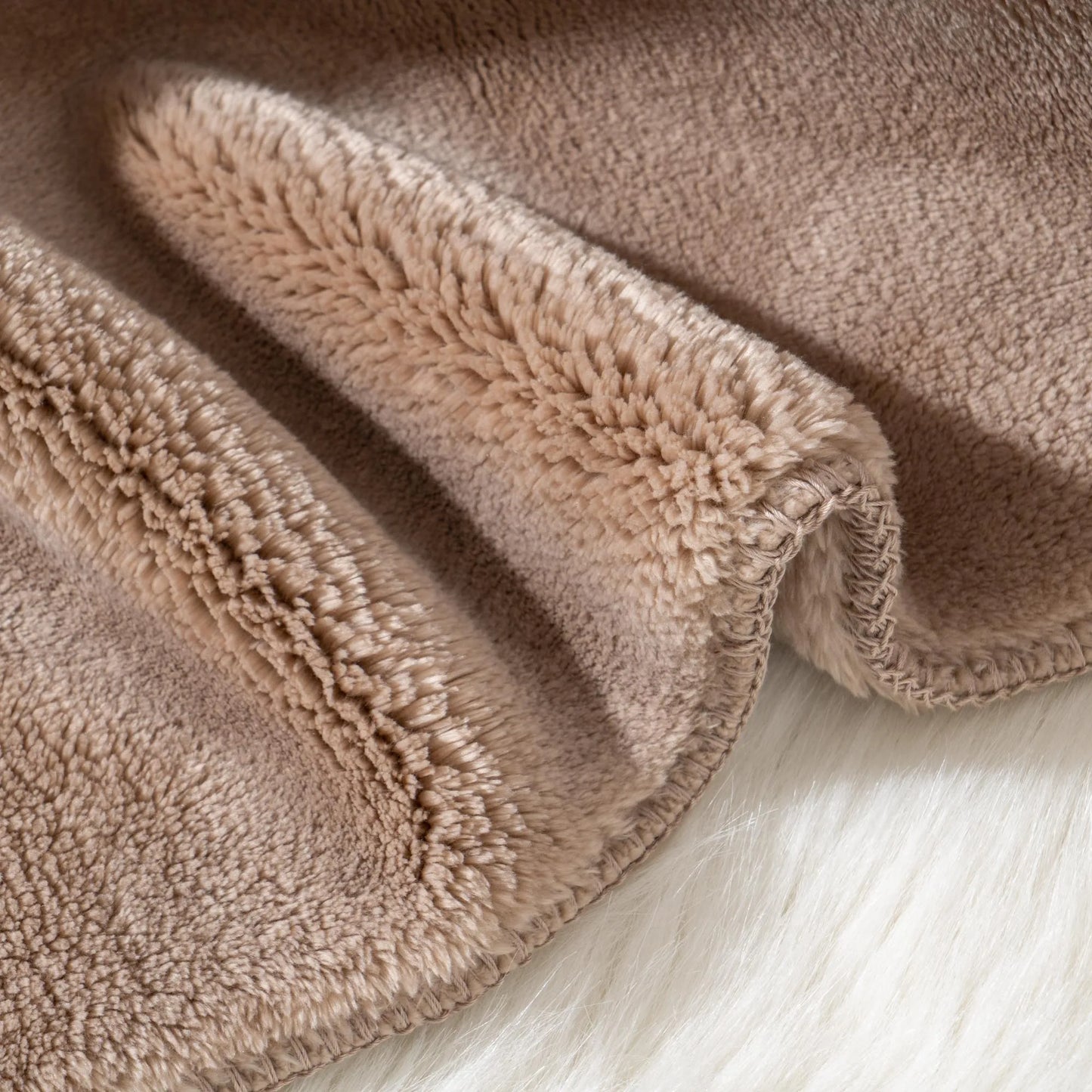 Cozy heavyweight plush flannel blanket draped over a couch, showcasing its thick and fuzzy texture.