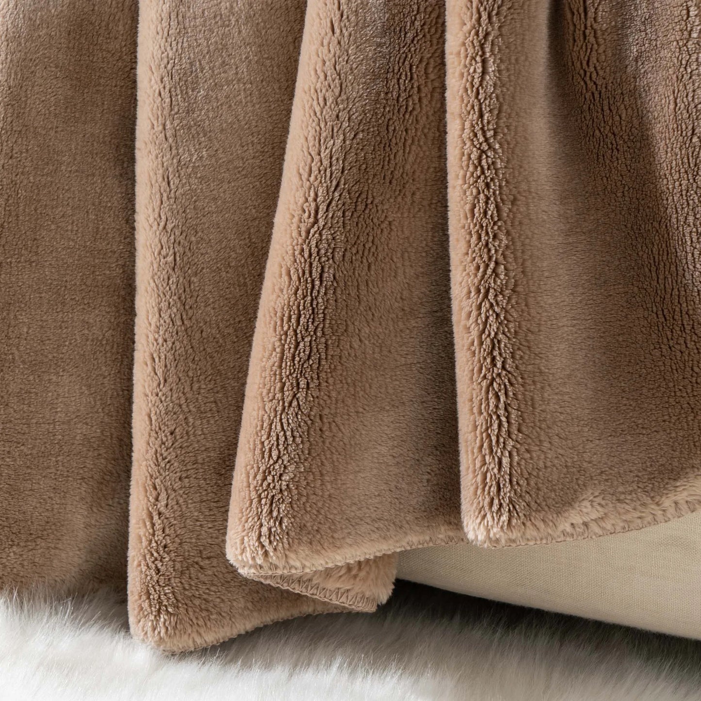 Cozy heavyweight plush flannel blanket draped over a couch, showcasing its thick and fuzzy texture.