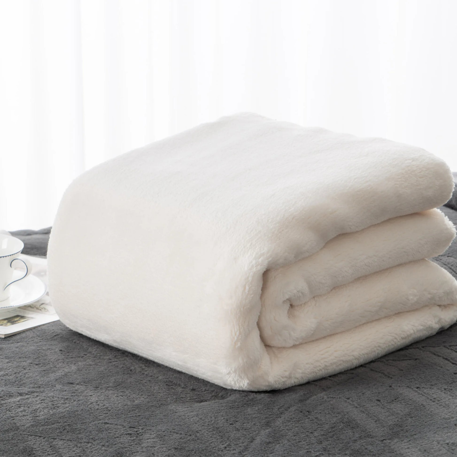 Cozy heavyweight plush flannel blanket draped over a couch, showcasing its thick and fuzzy texture.