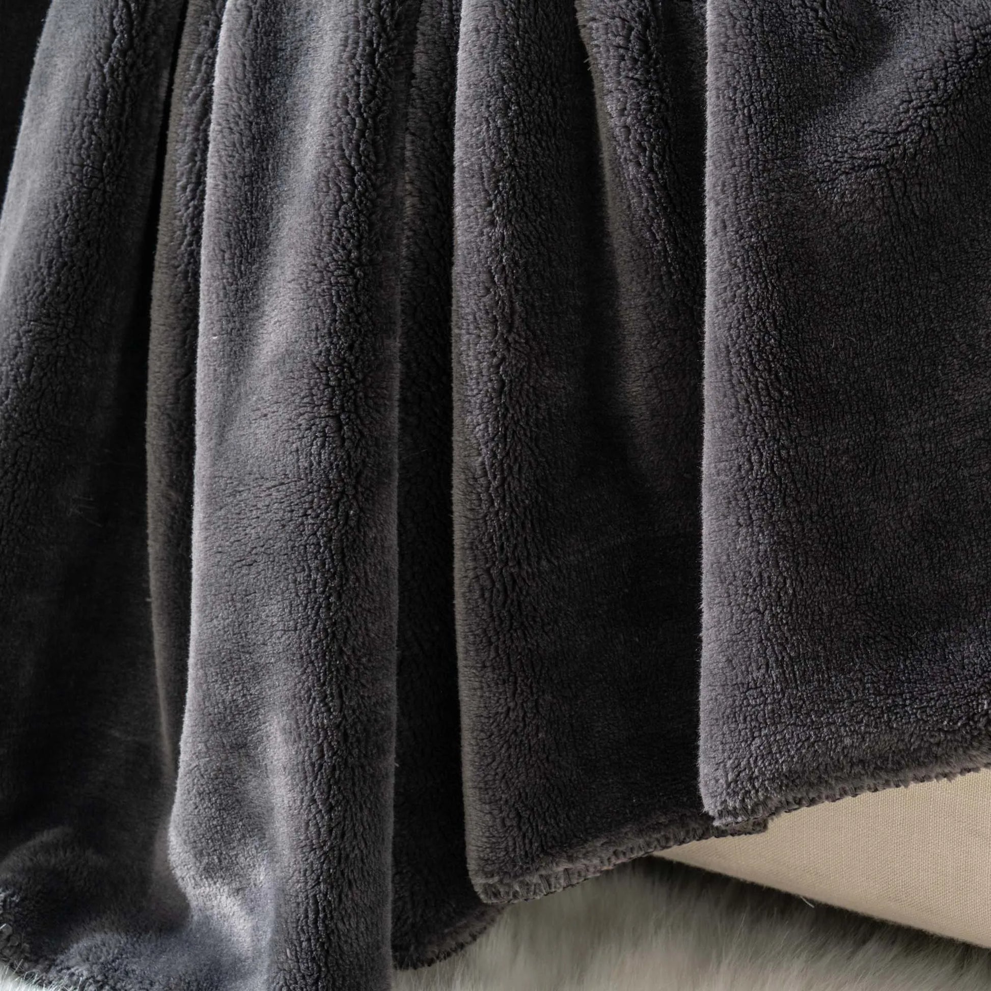 Cozy heavyweight plush flannel blanket draped over a couch, showcasing its thick and fuzzy texture.