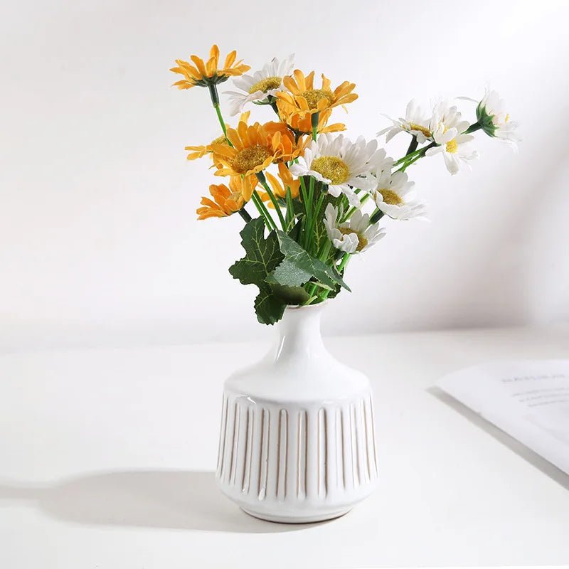 A creative ceramic vase filled with white and yellow flowers, showcasing an elegant and artistic arrangement perfect for home decor.