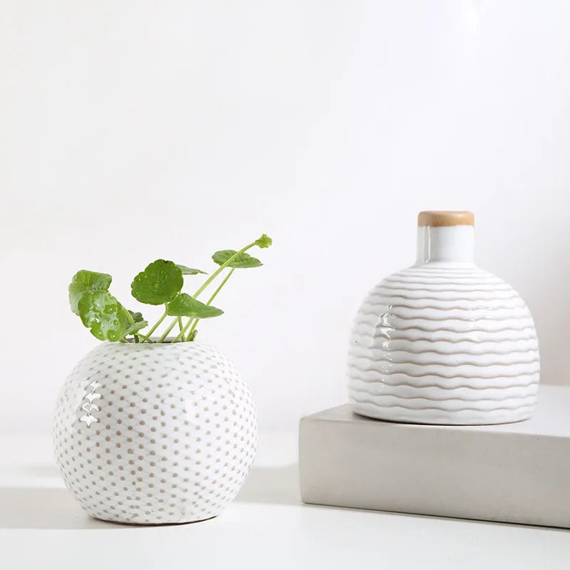 Two creative ceramic vases with different shapes placed on a table