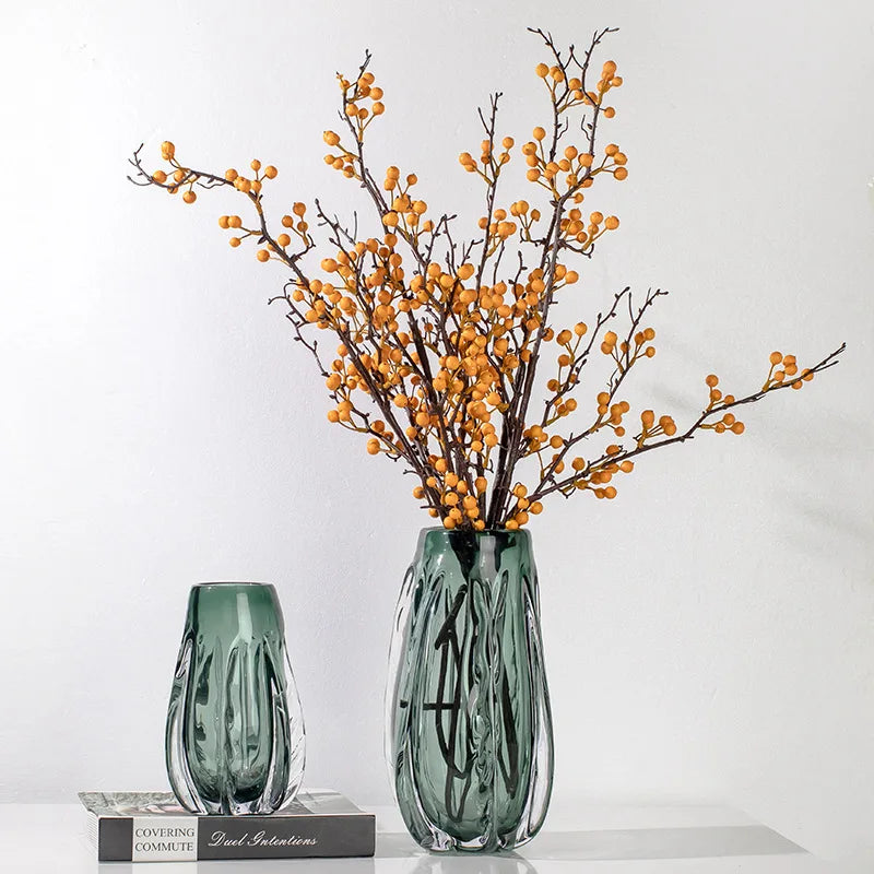 A green crystal vase with a sleek design for flowers or home decor.