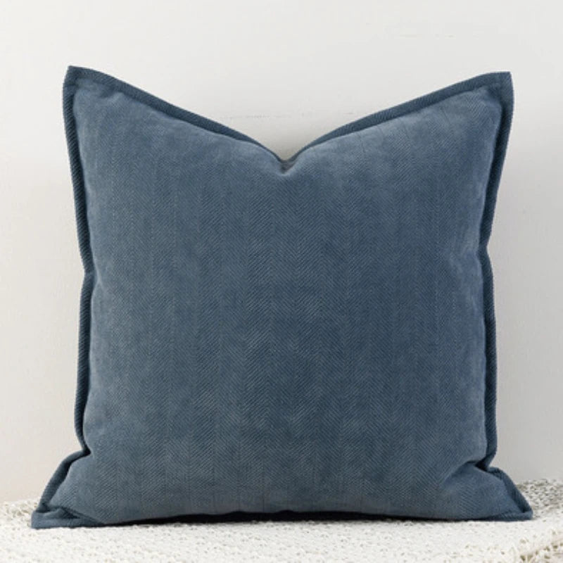 A dark-blue Nordic cushion cover placed over a couch, showcasing its delicate and cozy texture.