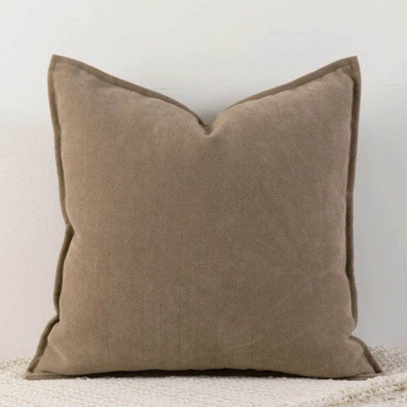 A dark brown Nordic cushion cover placed over a couch, showcasing its delicate and cozy texture.