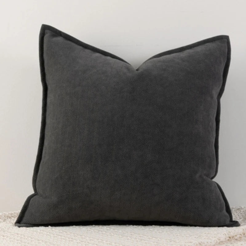 A dark gray Nordic cushion cover placed over a couch, showcasing its delicate and cozy texture.