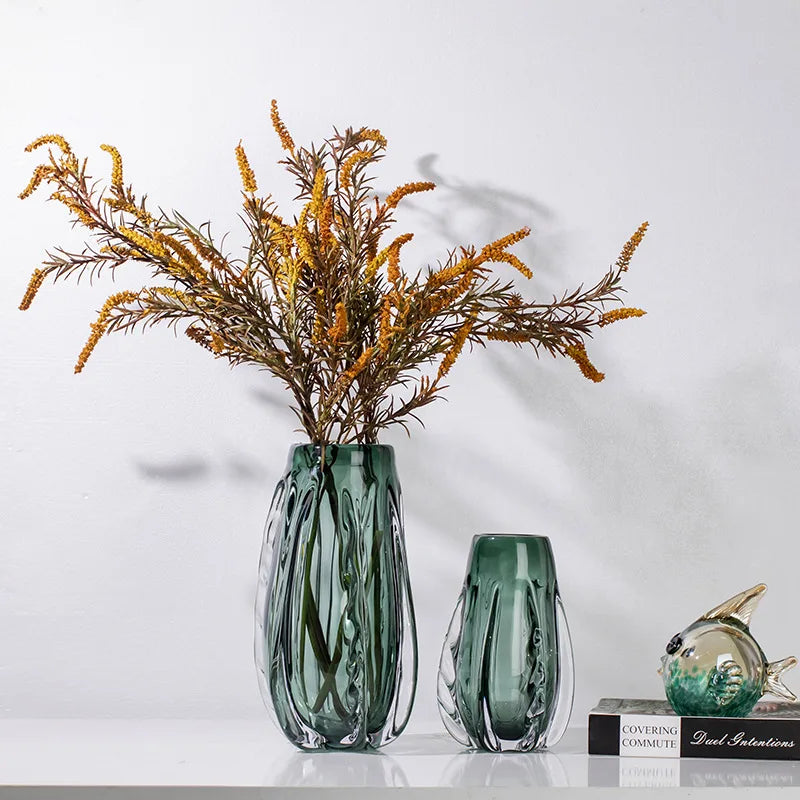 A green crystal vase with a sleek design for flowers or home decor.