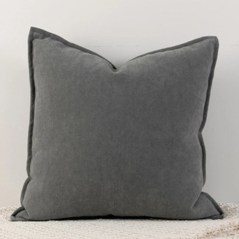 A gray Nordic cushion cover placed over a couch, showcasing its delicate and cozy texture.