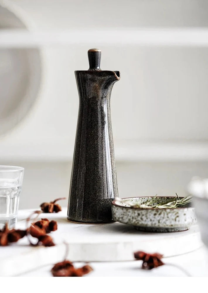 A gray vintage ceramic oil and vinegar dispenser with a classic design and decorative details