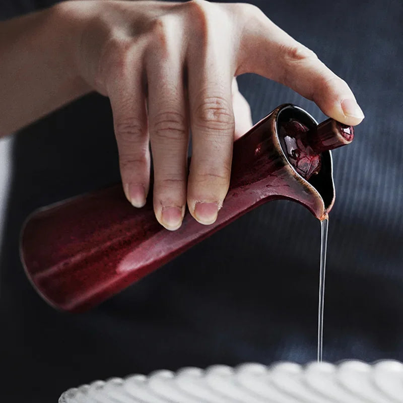 A gray vintage ceramic oil and vinegar dispenser with a classic design and decorative details