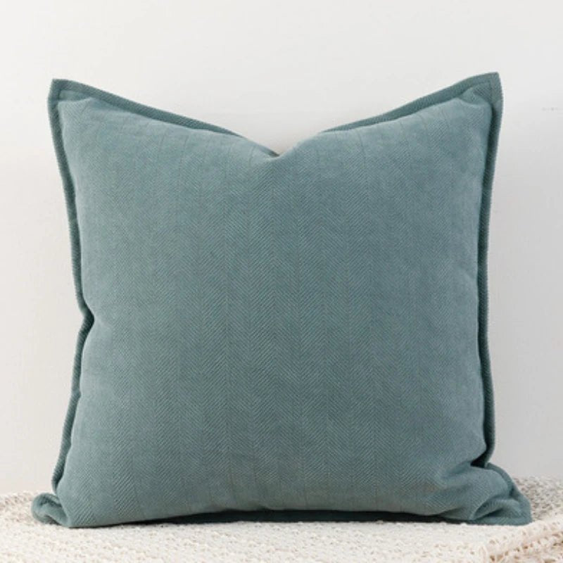 A haze blue Nordic cushion cover placed over a couch, showcasing its delicate and cozy texture