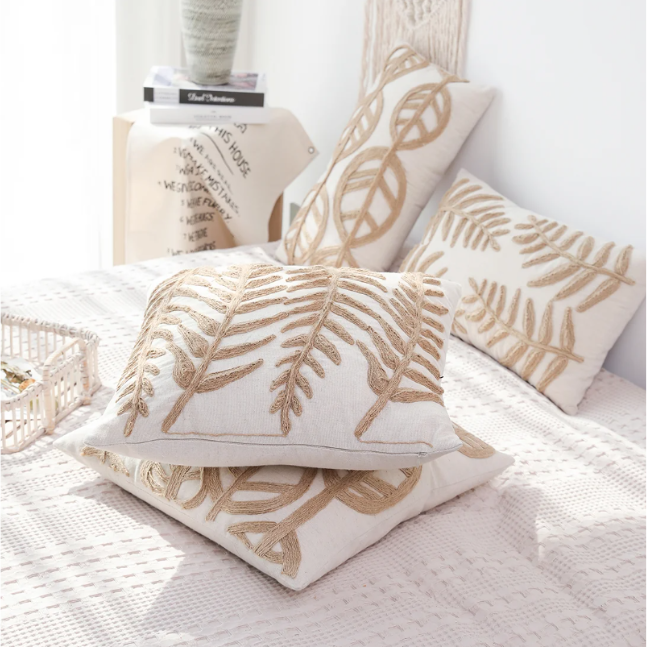 Boho-style linen pillow cover with beige fabric and embroidered leaf designs, ideal for adding charm and harmony to your home decor.