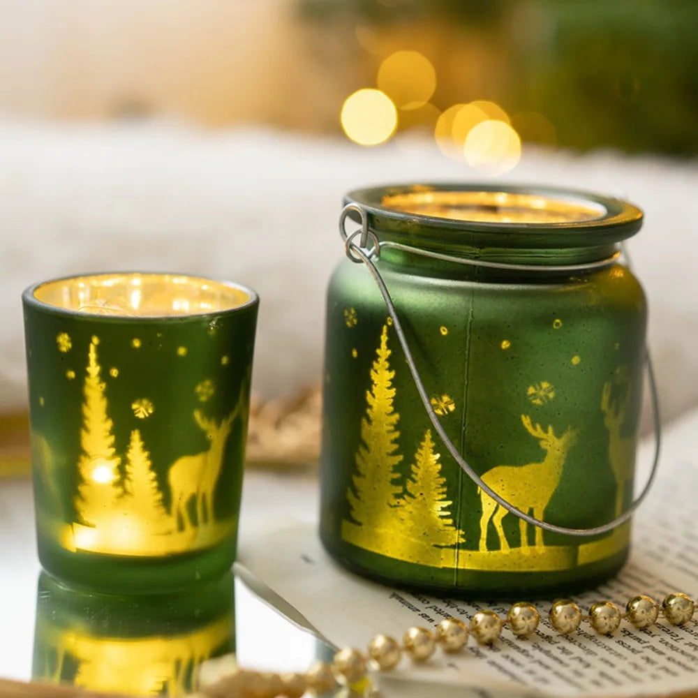 Christmas glass candle holders with etched winter scenes of pine trees and reindeer.