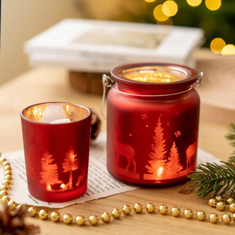 Christmas glass candle holders with etched winter scenes of pine trees and reindeer.