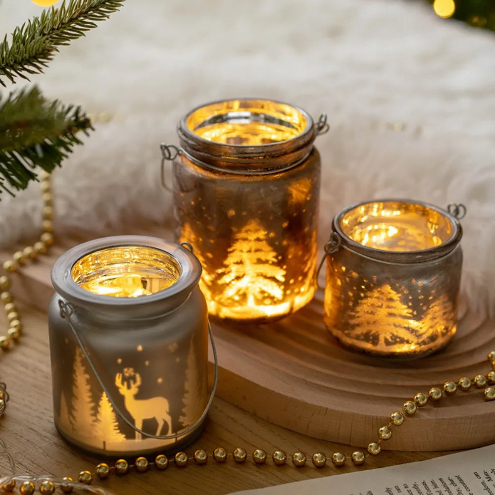 Christmas glass candle holders with etched winter scenes of pine trees and reindeer.