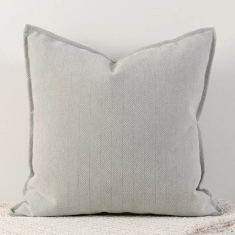 A milk tea ash Nordic cushion cover placed over a couch, showcasing its delicate and cozy texture.