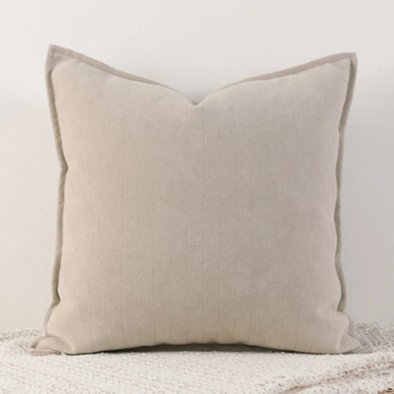 A milk tea Nordic cushion cover placed over a couch, showcasing its delicate and cozy texture.