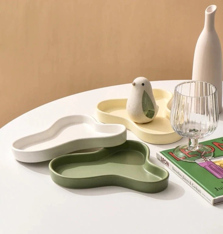 Minimalist irregular ceramic tray used as a coffee table centerpiece and jewelry storage.