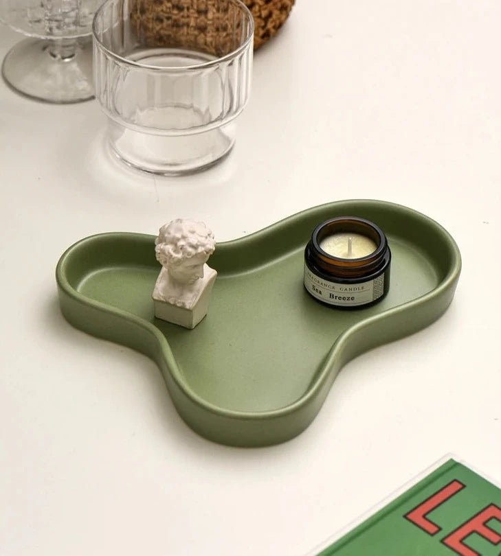 Minimalist irregular ceramic tray used as a coffee table centerpiece and jewelry storage.