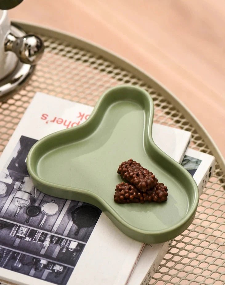 Minimalist irregular ceramic tray used as a coffee table centerpiece and jewelry storage.