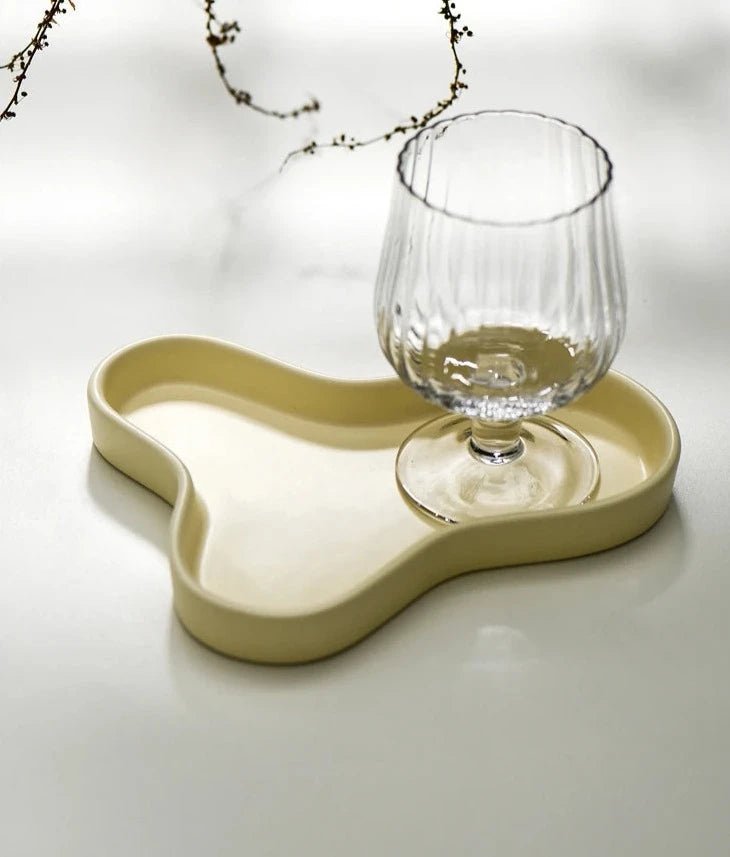 Minimalist irregular ceramic tray used as a coffee table centerpiece and jewelry storage.