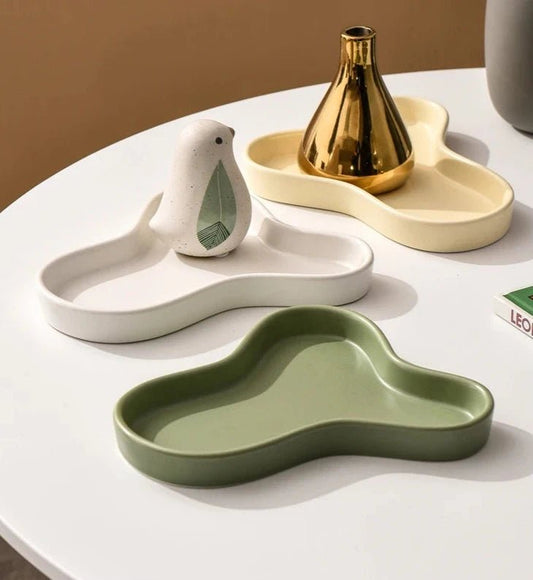 Minimalist irregular ceramic tray used as a coffee table centerpiece and jewelry storage.