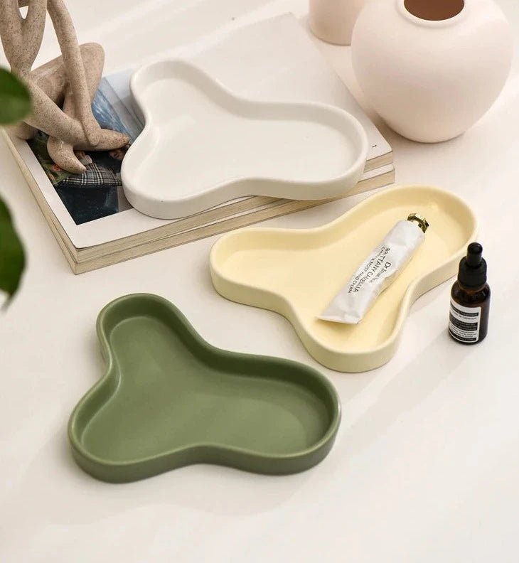 Minimalist irregular ceramic tray used as a coffee table centerpiece and jewelry storage.