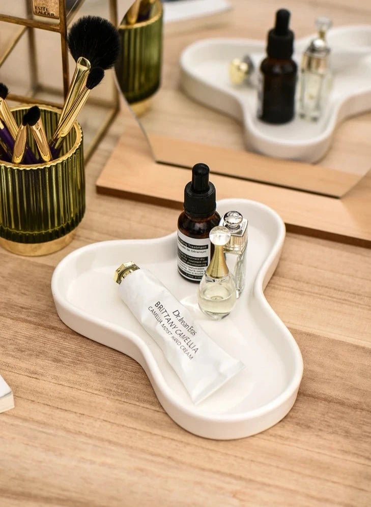 Minimalist irregular ceramic tray used as a coffee table centerpiece and jewelry storage.