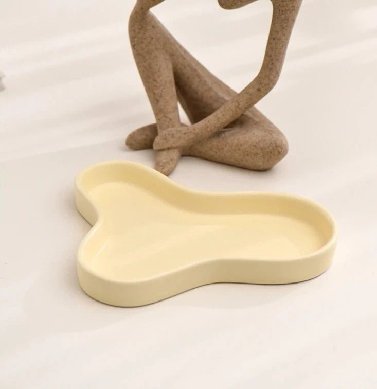 Minimalist irregular ceramic tray used as a coffee table centerpiece and jewelry storage.