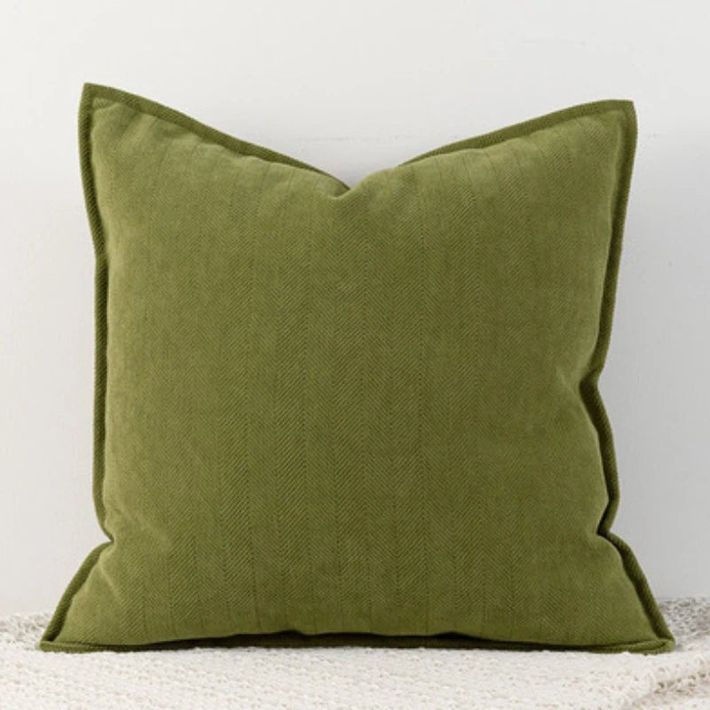 A olive green Nordic cushion cover placed over a couch, showcasing its delicate and cozy texture.