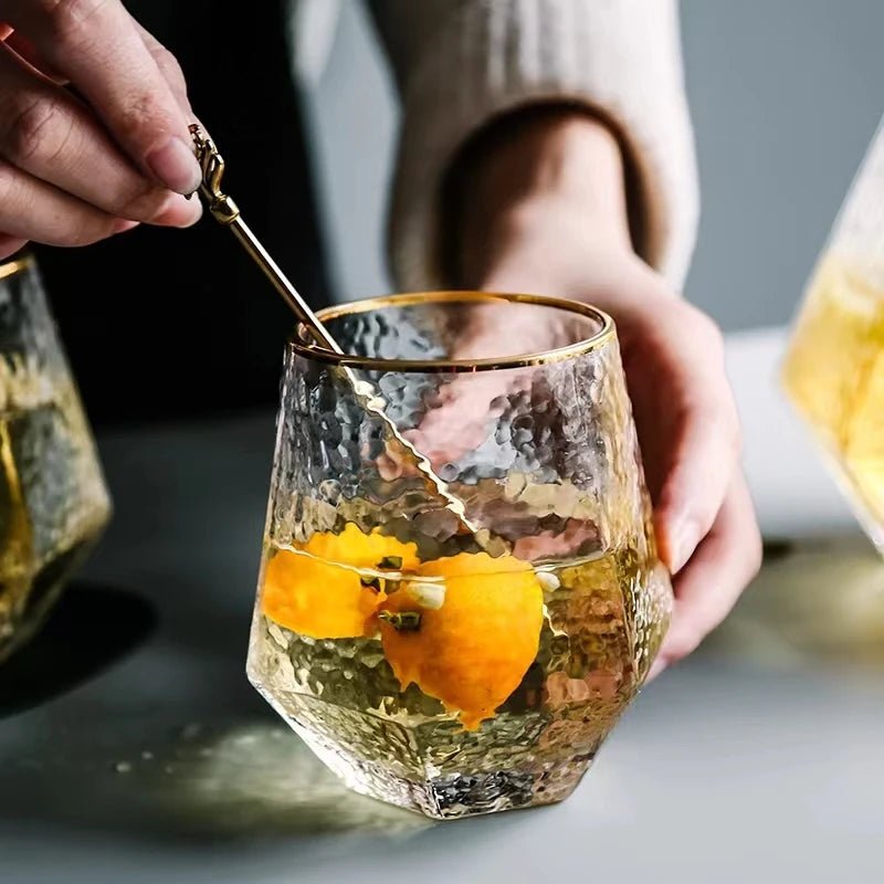 A person mixing water and slices of lemon in a cup