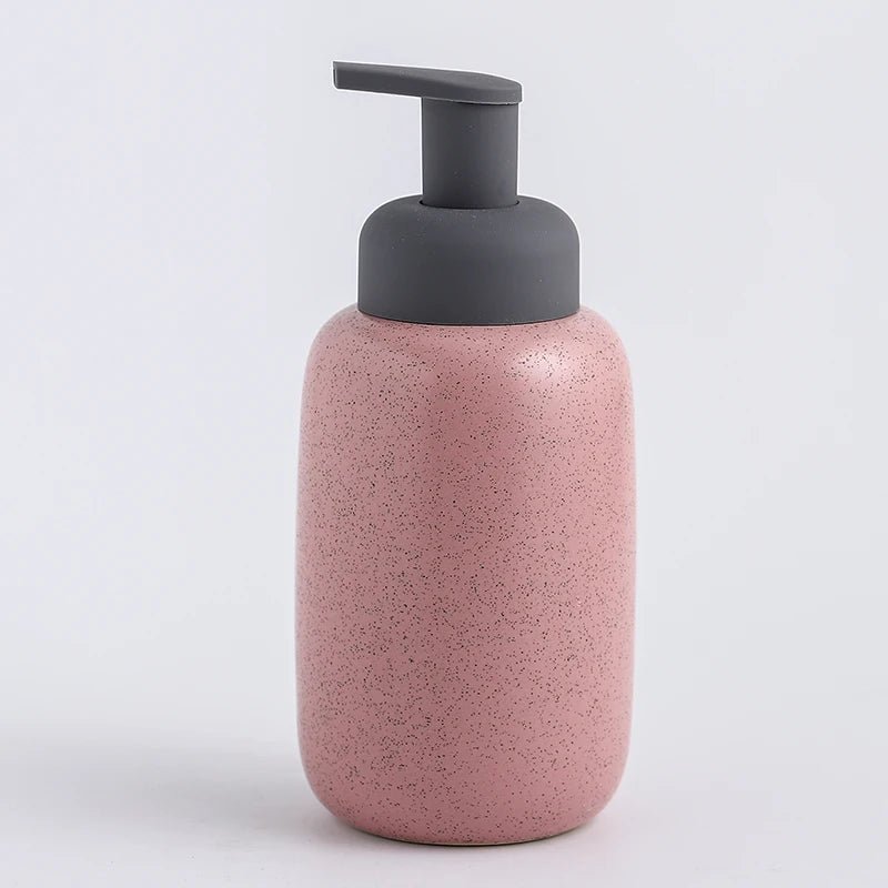 A pink ceramic soap dispenser with a sleek design, ideal for modern bathroom decor.