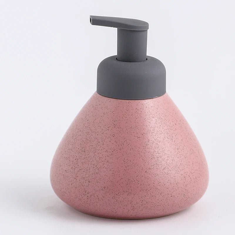 A pink ceramic soap dispenser with a sleek design, ideal for modern bathroom decor.