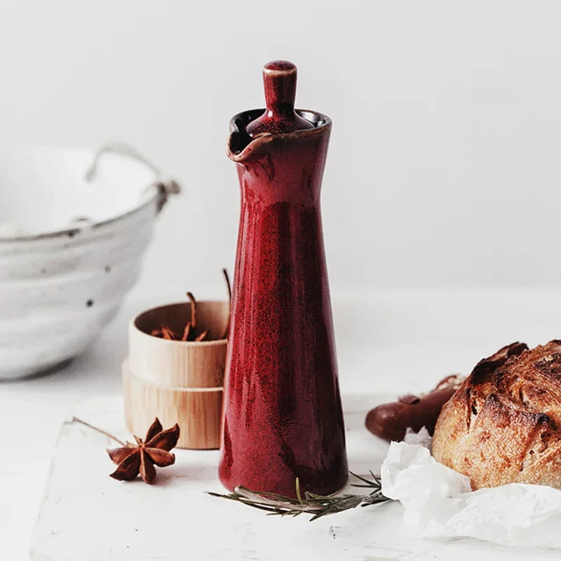 A red vintage ceramic oil and vinegar dispenser with a classic design and decorative details